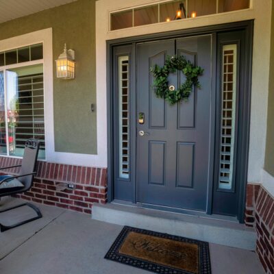 A front door with a holiday wreath is pictured.